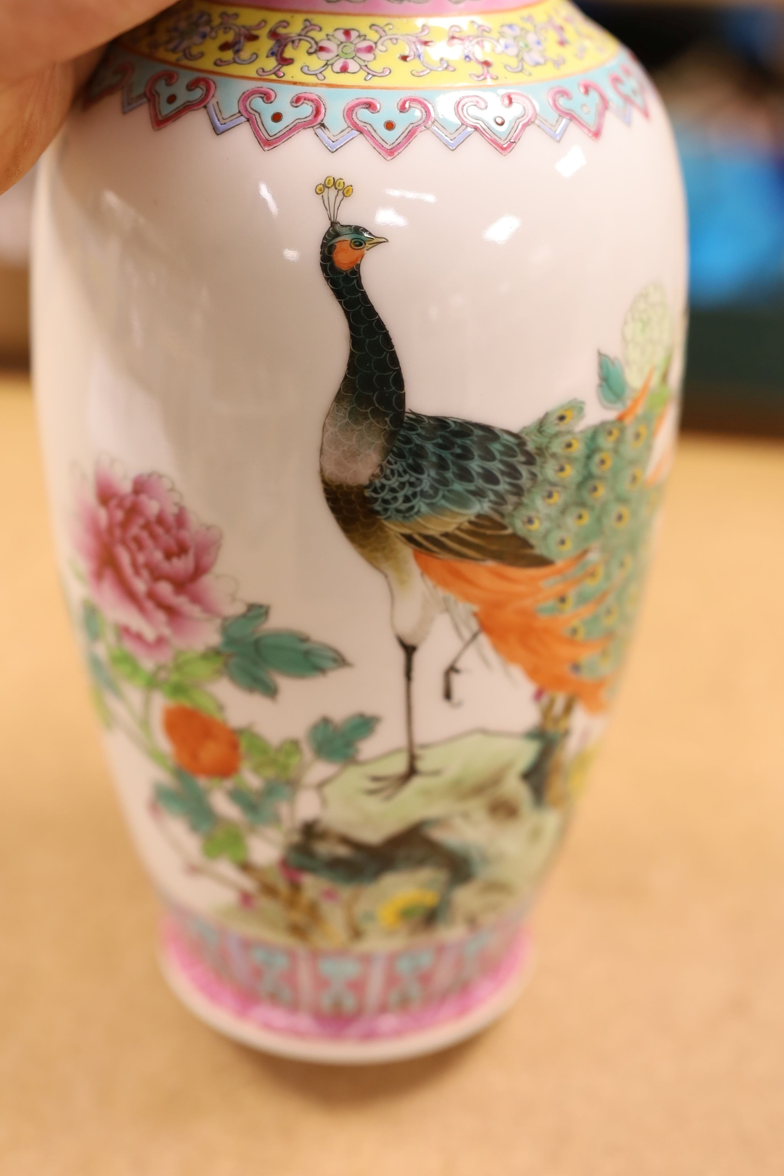 A pair of Chinese famille rose vases decorated with peacocks, 31cm